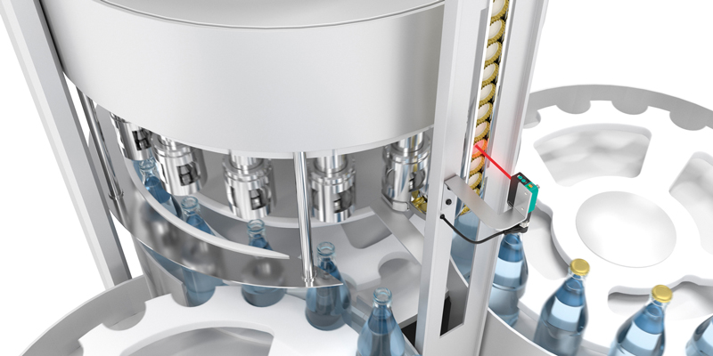 photoelectric_sensors_cap_feeding_control_bottling_machine R201 series diffuse mode sensor monitors the automated cap feed in a filling machine