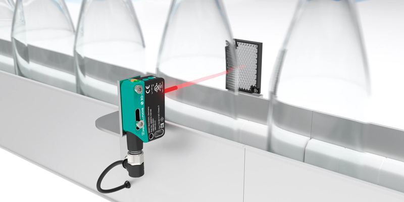 photoelectric_sensors_r201_bottling_detecting_transparent_objects Pepperl+Fuchs R201 retroreflective sensor reliably detects clear glass bottles in an automated filling machine