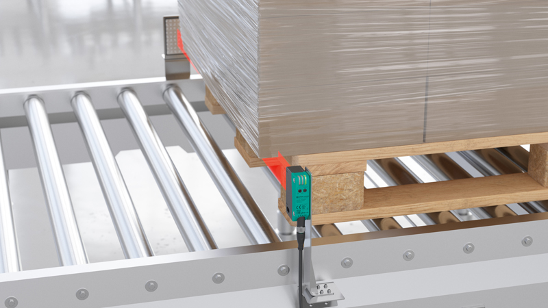 R305 retroreflective area sensor mounted on roller conveyor, detecting a pallet
